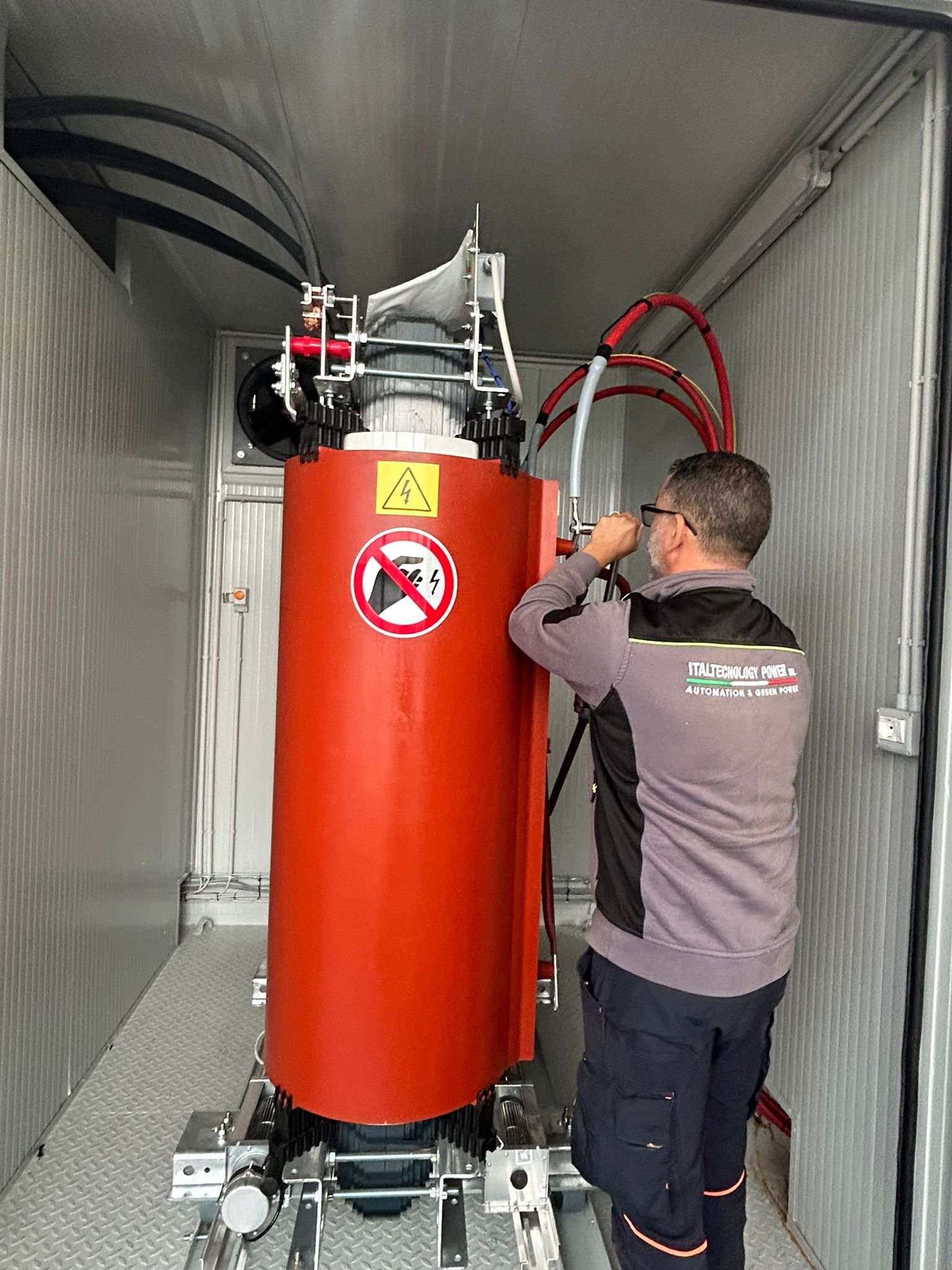 Tecnico accanto a un’apparecchiatura di protezione in una cabina elettrica